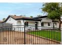 Stylish home showcasing a decorative fence and a lush green lawn, enhancing curb appeal at 833 S Toltec --, Mesa, AZ 85204