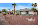 Well maintained single story house with rock landscaping, palm trees, and trimmed shrubbery, with green trim at 848 W Keating Ave, Mesa, AZ 85210