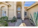 Close up of a beige single-Gathering home featuring a front entrance with an arched alcove and desert landscaping at 12125 N 91St Way, Scottsdale, AZ 85260