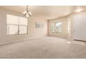 Bright and airy living room featuring large windows, neutral walls, and plush carpeting at 12508 W Highland Ave, Litchfield Park, AZ 85340
