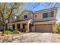 Charming two-story home with a covered porch, well-kept yard, and attached two-car garage at 14363 W Acapulco Ln, Surprise, AZ 85379
