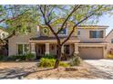 Inviting two-story home featuring a front porch, well-maintained landscaping, and a two-car garage at 14363 W Acapulco Ln, Surprise, AZ 85379