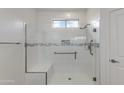 Modern bathroom shower featuring a built-in seat, grab bar, and sleek glass enclosure at 15046 W Cooperstown Way, Surprise, AZ 85374