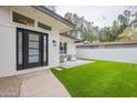 This backyard features a lush lawn, a cozy patio set, and sleek modern design at 15255 N 5Th Ln, Phoenix, AZ 85023