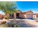 Well-kept home with desert landscaping and a two-car garage on a sunny day at 17633 W Wind Song Ave, Goodyear, AZ 85338