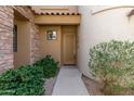 Close-up view of a neutral colored door framed by desert landscaping at 19550 N Grayhawk Dr # 1044, Scottsdale, AZ 85255