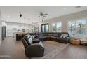 Open-concept living room with wood floors, a comfortable leather sofa, and a view of the backyard at 25454 N 73Rd Ave, Peoria, AZ 85383