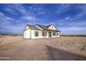 A view of the side of the house showing the covered patio and the wide open space of the lot at 28003 N Faded Creek Dr, Florence, AZ 85132