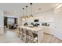 Well-lit kitchen with white cabinets, a quartz island with bar seating, and modern stainless steel appliances at 4661 E French Rd, San Tan Valley, AZ 85143