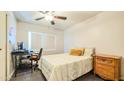 Cozy bedroom with a comfortable bed, desk, ceiling fan and warm lighting, creating an inviting space at 7217 W Claremont St, Glendale, AZ 85303