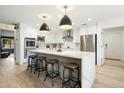 Modern kitchen with a large island, stainless steel appliances, pendant lighting, and seating for four at 9331 S Lakeshore Dr, Tempe, AZ 85284