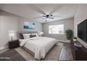 Spacious main bedroom with ceiling fan, large window, and view of TV on dresser at 10411 N 11Th Ave # 28, Phoenix, AZ 85021