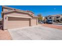 Three car garage and extended driveway offer generous parking and attractive desert landscaping at 1202 W Central Ave, Coolidge, AZ 85128