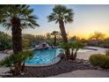 Tranquil pool and waterfall feature surrounded by mature palm trees at 12083 E Wethersfield Dr, Scottsdale, AZ 85259