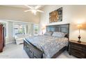 This main bedroom features a king bed, sitting area, vaulted ceilings, and neutral decor at 14385 W Morning Star Trl, Surprise, AZ 85374