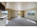 Bright living room featuring plush carpet, neutral paint, and views of lush palm trees at 14620 N Yerba Buena Way # D, Fountain Hills, AZ 85268