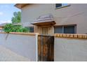 Two-story condo features a brick privacy wall with a wooden gate leading to a charming entryway with decorative awning at 17031 E Calle Del Oro -- # B, Fountain Hills, AZ 85268