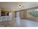 Open-concept living room features tile flooring, a kitchen with breakfast bar, and a large window providing natural light at 17031 E Calle Del Oro -- # B, Fountain Hills, AZ 85268