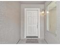 Close-up of a white front door with welcome mat and exterior lighting fixture at 1715 E Branham Ln, Phoenix, AZ 85042