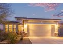 A well-lit single-story home boasts a two-car garage, accented by brick and desert landscaping at 17796 W Sandy Rd, Goodyear, AZ 85338