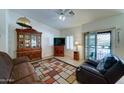 Open-concept living room with a decorative rug, ceiling fan, sliding doors to the exterior, and a hutch at 2101 S Meridian Rd # 190, Apache Junction, AZ 85120