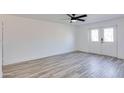 Bright bedroom featuring wood-look floors, a ceiling fan, and a large window for ample natural light at 2217 E Sheridan St, Phoenix, AZ 85006