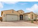 A house with a three-car garage and desert landscaping creates a warm, inviting curbside appeal at 3408 S 184Th Ln, Goodyear, AZ 85338