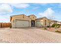 A wide, paved driveway leads to this house with three-car garage, complemented by desert landscaping at 3408 S 184Th Ln, Goodyear, AZ 85338