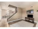 Spacious living room featuring a staircase, neutral decor, and modern entertainment setup at 3511 E Baseline Rd # 1076, Phoenix, AZ 85042