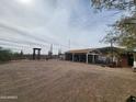 Exterior view of the open garage structure and surrounding desert landscape at 37448 N 301St Ave, Wittmann, AZ 85361