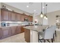 Kitchen with granite island, barstool seating, stainless appliances, and ample cabinet space at 3931 N 163Rd Dr, Goodyear, AZ 85395