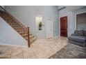 Bright foyer features tiled floors, staircase with dark wood banister, and gray colored walls at 4032 W Lydia Ln, Phoenix, AZ 85041