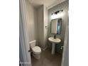 Stylish half-bath featuring a pedestal sink, modern faucet, and a geometric-patterned backsplash at 41260 W Palmyra Ln, Maricopa, AZ 85138