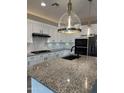 Modern kitchen featuring a center island with a granite countertop, white cabinets, and stainless steel appliances at 41260 W Palmyra Ln, Maricopa, AZ 85138