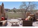 This tiled balcony provides a relaxing space with golf course views and comfortable seating at 10222 E Southwind Ln # 1054, Scottsdale, AZ 85262