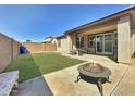 Inviting backyard with lush lawn, covered patio, and stylish fire pit, perfect for outdoor entertaining at 10419 W Papago St, Tolleson, AZ 85353