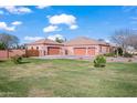 Spacious home featuring a large manicured lawn and multiple garages offering ample parking and storage space at 1096 W Via De Palmas --, San Tan Valley, AZ 85140