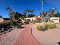 Attractive home featuring a red brick walkway surrounded by desert landscaping and palm trees at 11018 N 42Nd St, Phoenix, AZ 85028