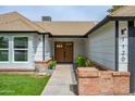 Charming single Gathering home entrance featuring brick accents, a well manicured lawn and an ADT security sign at 1120 W Barrow Dr, Chandler, AZ 85224