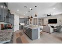 Modern kitchen with gray cabinets, an island with seating, and an open floor plan at 12047 E Sereno Rd, Gold Canyon, AZ 85118