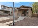 Inviting single-Gathering home featuring a covered porch with stone pillars, a two-car garage, and desert landscaping at 1473 W Flamingo Dr, Chandler, AZ 85286