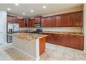 Spacious kitchen featuring granite countertops, stainless steel appliances, and beautiful dark wood cabinetry at 15290 W Ventura St, Surprise, AZ 85379