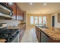 Gourmet kitchen featuring granite countertops, stainless steel appliances, and a view of the backyard at 15290 W Ventura St, Surprise, AZ 85379