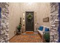 Charming front porch with a decorative wreath, bench with blue pillows, and decorative plants at 20088 E Maya Rd, Queen Creek, AZ 85142