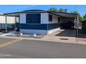 Charming mobile home featuring covered parking and white and blue color scheme at 205 S Higley Rd # 8, Mesa, AZ 85206