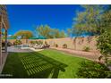 Lush backyard with artificial turf, pool, patio furniture, and privacy wall at 26991 N 97Th Ln, Peoria, AZ 85383