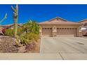 Charming single-story home with a well-maintained desert landscape and a spacious three-car garage at 26991 N 97Th Ln, Peoria, AZ 85383