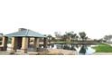 Relaxing waterside view of the community gazebo and pond reflecting the blue sky at 36765 W Mediterranean Way, Maricopa, AZ 85138