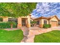 Charming home featuring lush green lawn, mature shade tree, and meticulously maintained desert landscaping at 3682 S Rosemary Dr, Chandler, AZ 85248