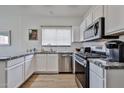 Well-lit kitchen with stainless steel appliances, white cabinets, and granite countertops at 3925 W Hackamore Dr, Phoenix, AZ 85083